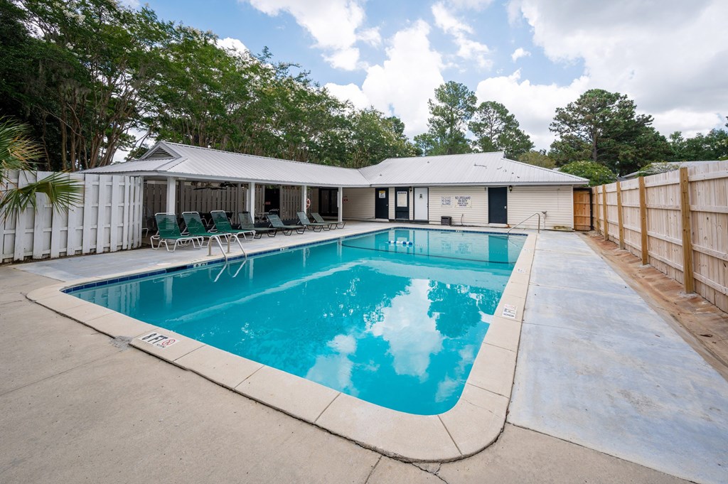 A pool in a backyard with a house in the background at The Landing Townhomes Apartments, Hanahan, South Carolina