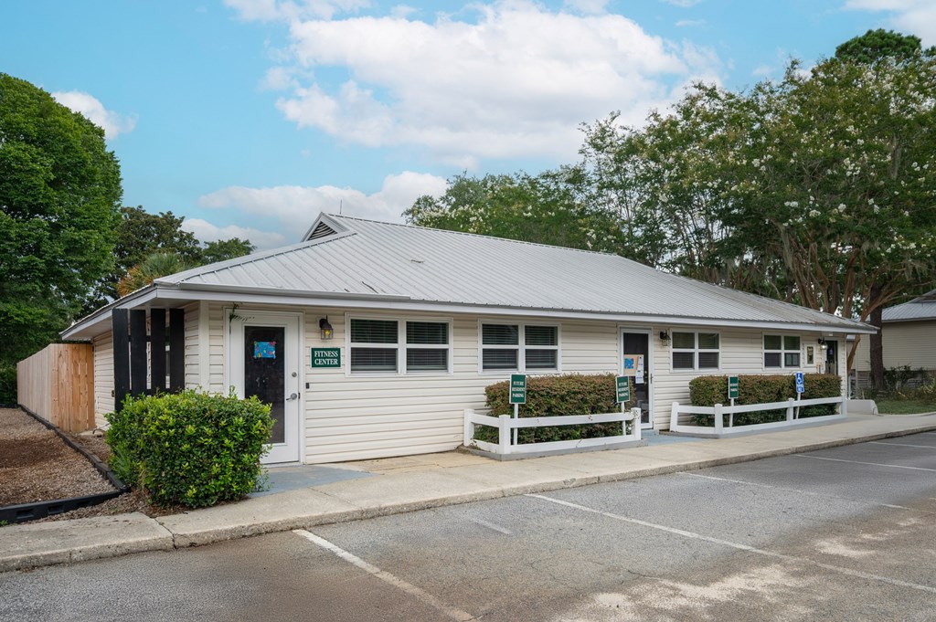 A small white building with a grey roof and a green sign on the front at The Landing Townhomes Apartments, Hanahan, SC