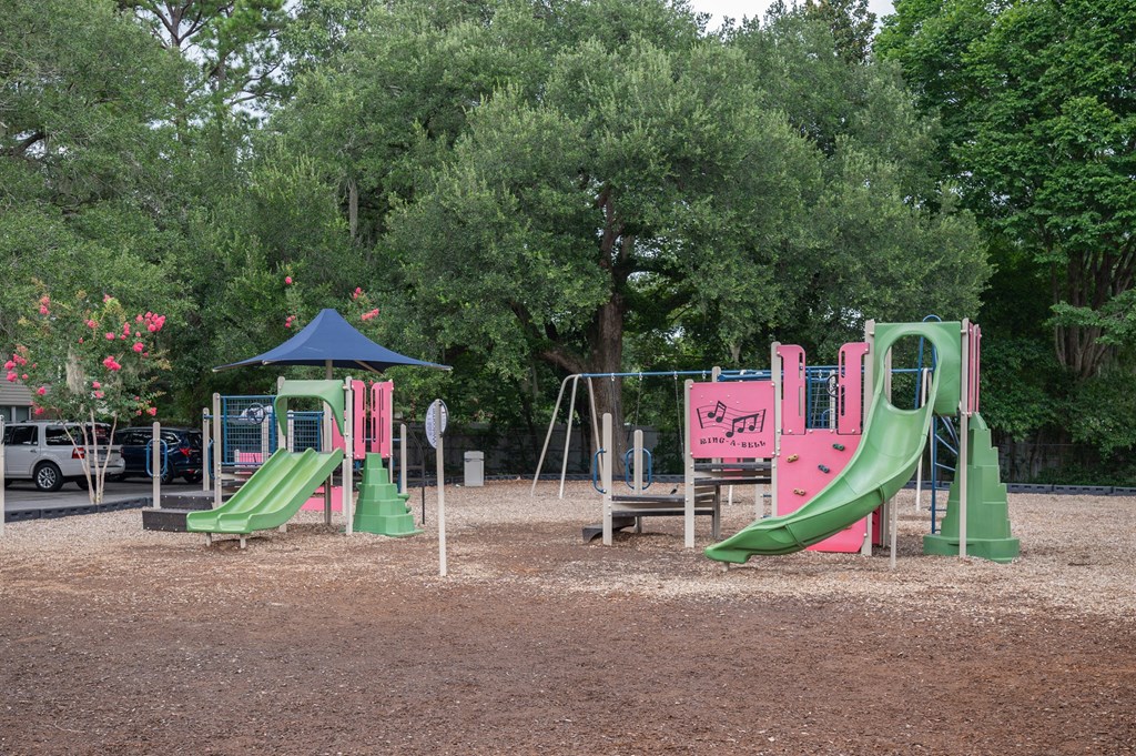 A playground with a green slide and a pink slide. at The Landing Townhomes Apartments, Hanahan, SC, 29410