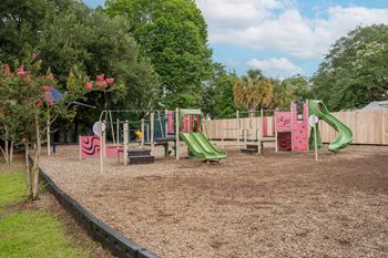 A playground with a green slide and a red slide at The Landing Townhomes Apartments, Hanahan, SC, 29410