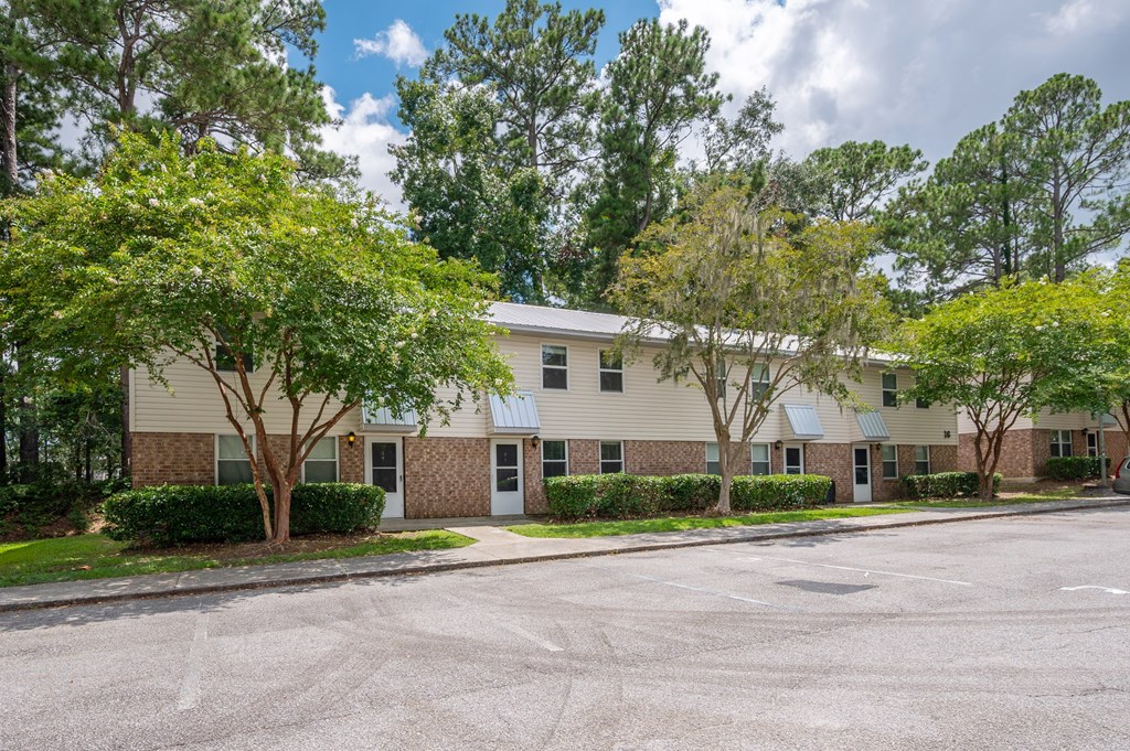 A building with a parking lot in front of it. at The Landing Townhomes Apartments, Hanahan, SC, 29410