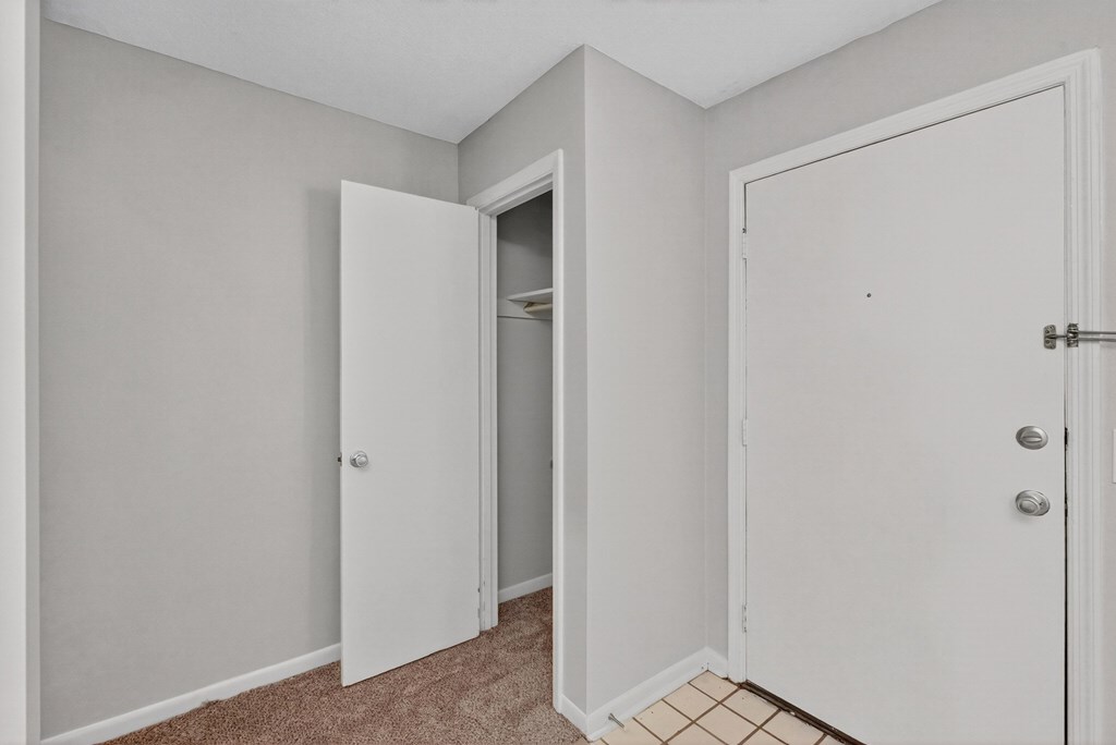A room with a white door and a white closet with a shelf inside at The Landing Townhomes Apartments, Hanahan, SC
