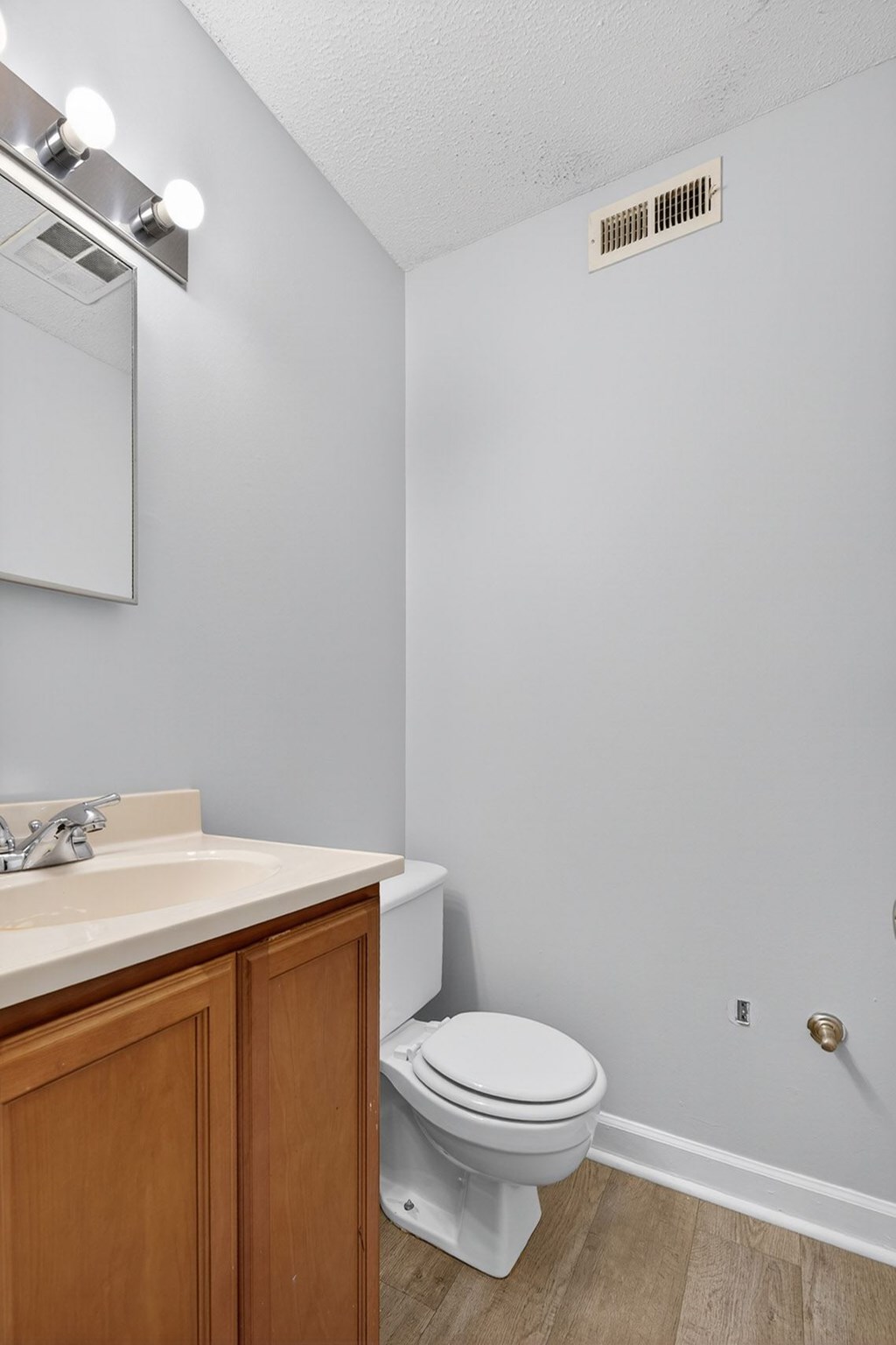 A white toilet sits in a bathroom next to a sink at The Landing Townhomes Apartments, South Carolina, 29410