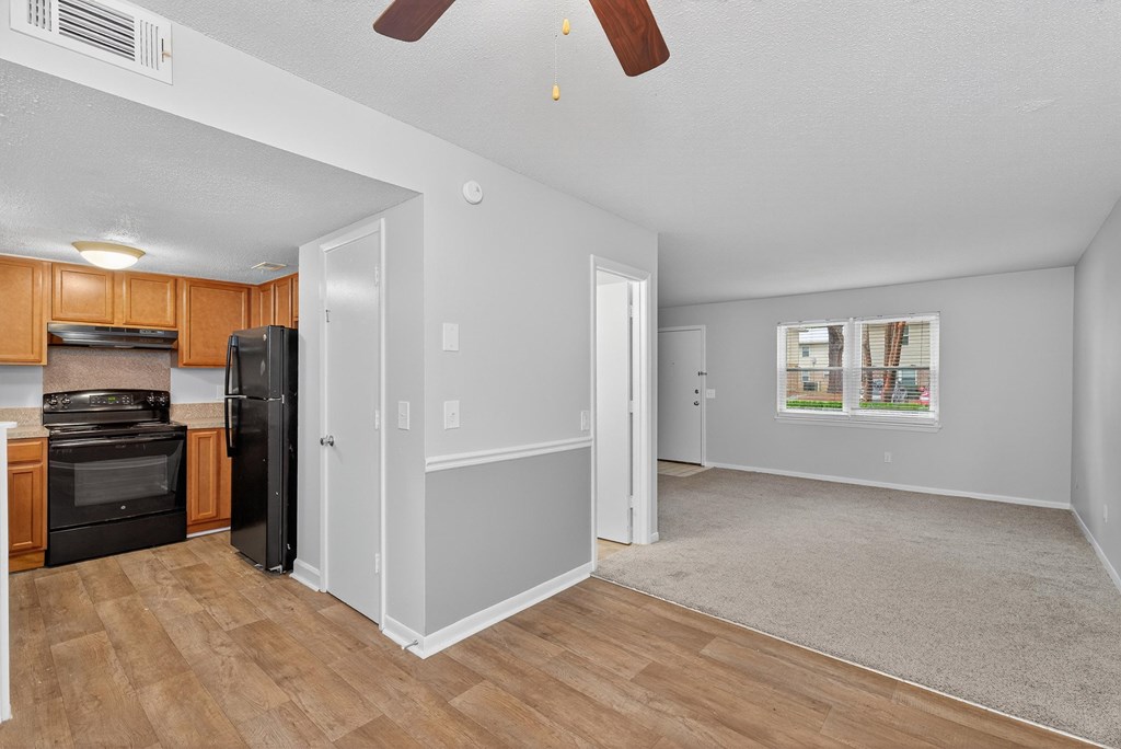A kitchen with a black refrigerator and stove top oven at The Landing Townhomes Apartments, Hanahan