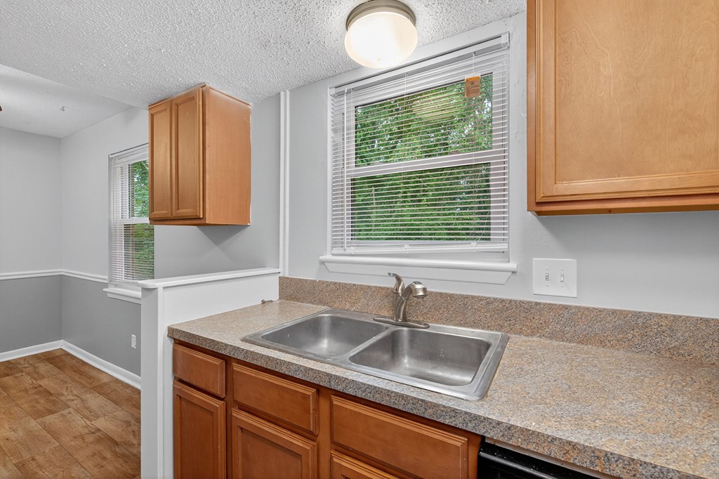 A kitchen with a sink and wooden cabinets at The Landing Townhomes Apartments, Hanahan, SC, 29410