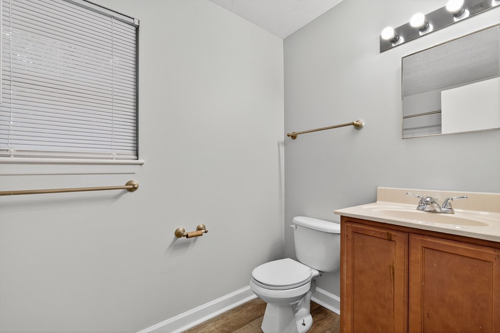 A white toilet sits in a bathroom next to a sink at The Landing Townhomes Apartments, Hanahan