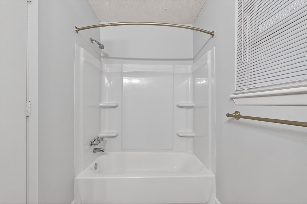 A white bathroom with a tub, sink, and towel rack at The Landing Townhomes Apartments, South Carolina
