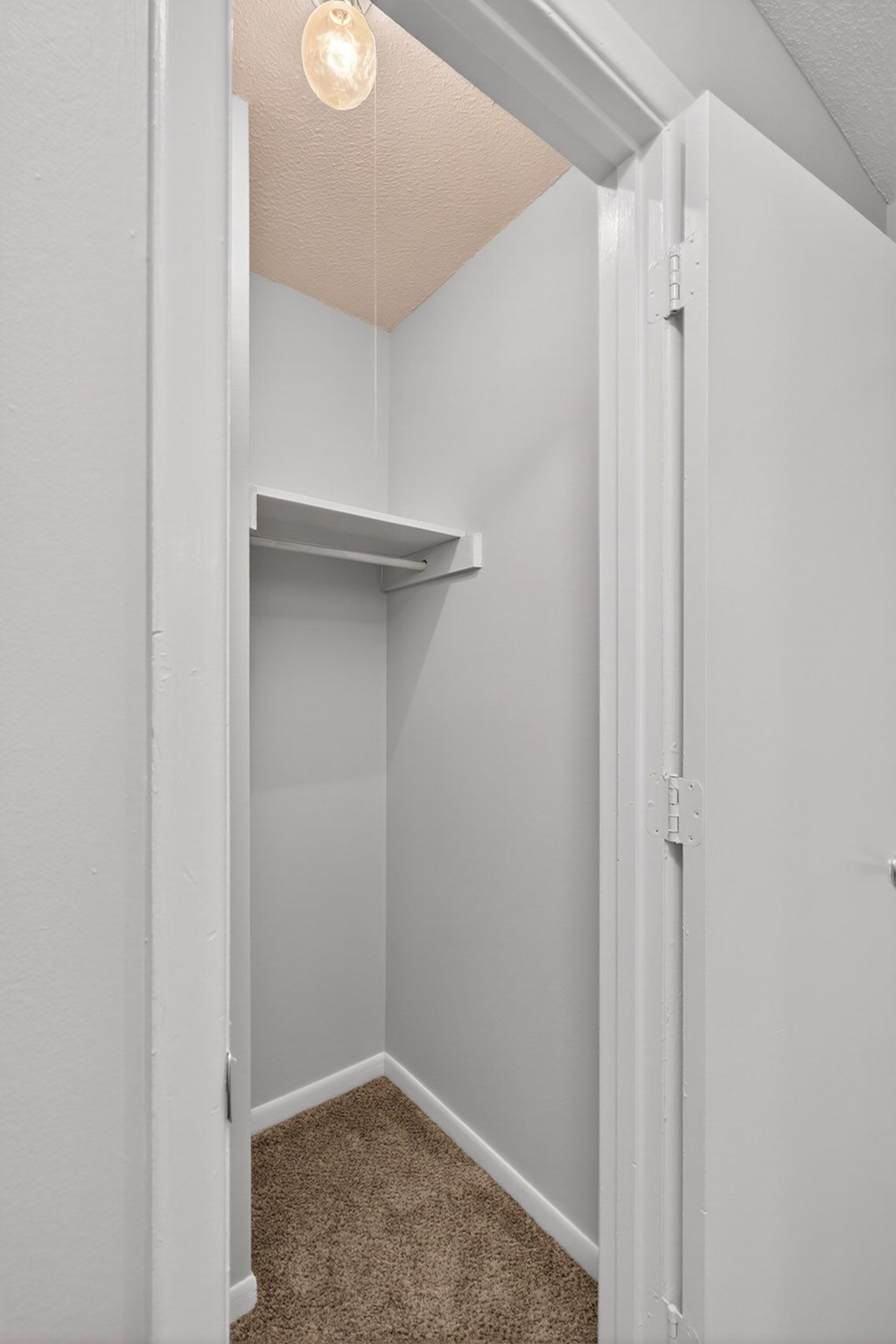 A white door is open to a small room with a carpeted floor at The Landing Townhomes Apartments, Hanahan, South Carolina