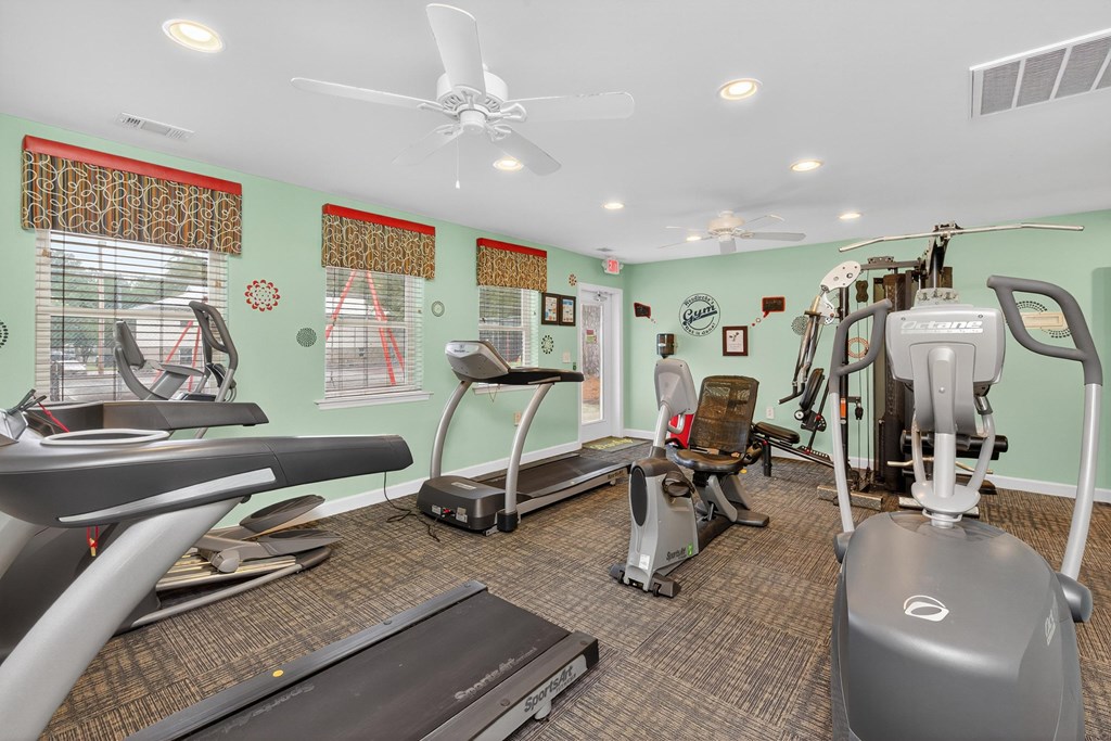 A gym with treadmills, elliptical machines, and other exercise equipment at Woodlocke Apartments, Moncks Corner, South Carolina