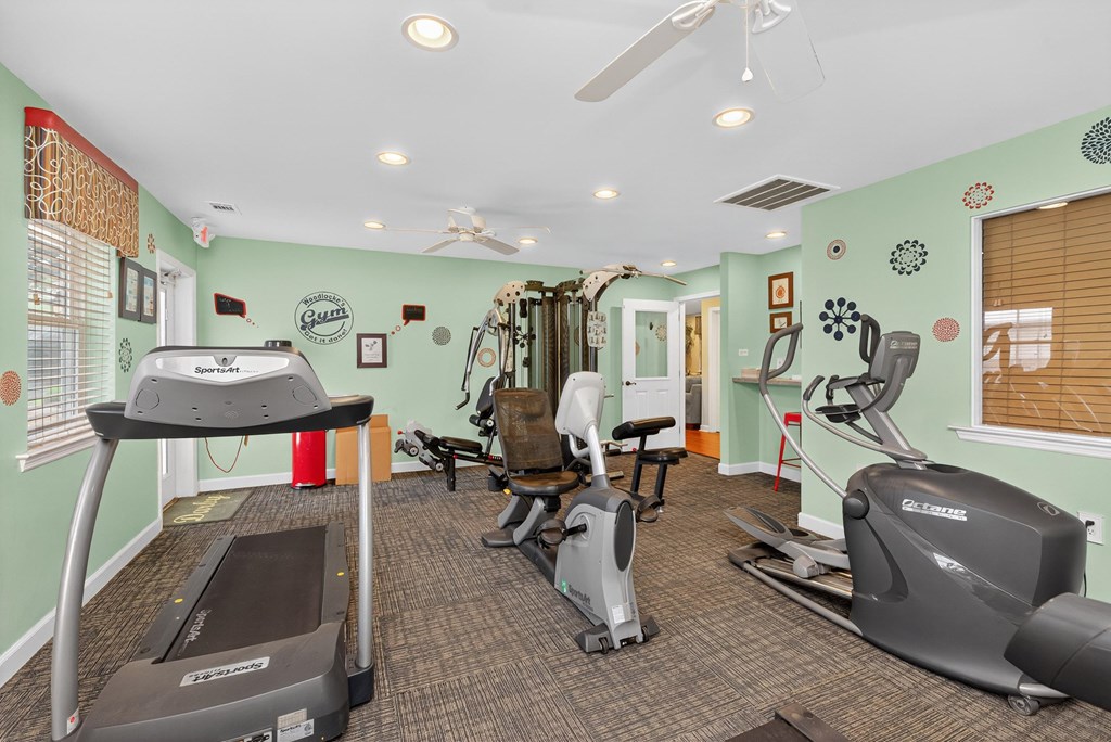 A gym with treadmills, exercise bikes, and other equipment at Woodlocke Apartments, Moncks Corner 27461