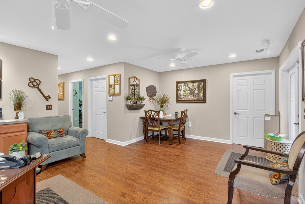 A living room with a couch, chairs, and a dining table at Woodlocke Apartments, Moncks Corner