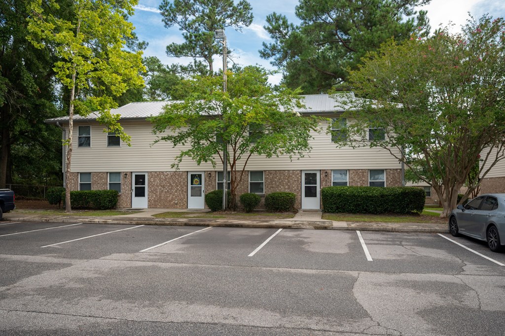 A parking lot in front of a two-story apartment building at Woodlocke Apartments, Moncks Corner, South Carolina