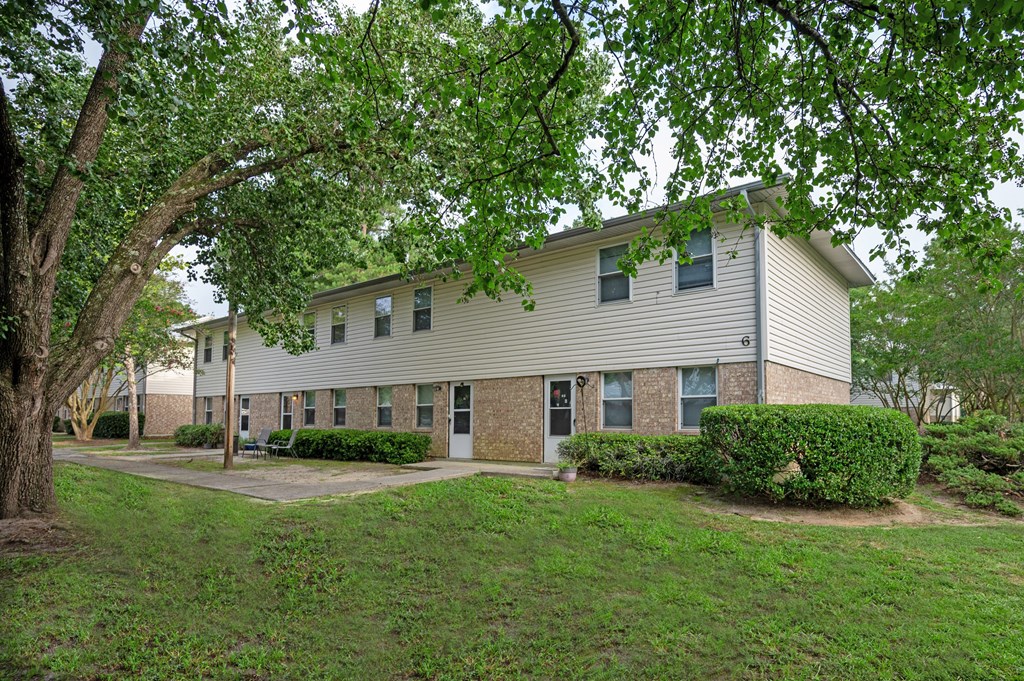 A beige house with a tree in front at Woodlocke Apartments, South Carolina
