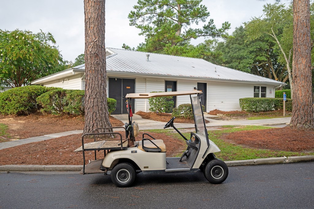 A golf cart is parked on the street in front of a house at Woodlocke Apartments, Moncks Corner, SC, 27461