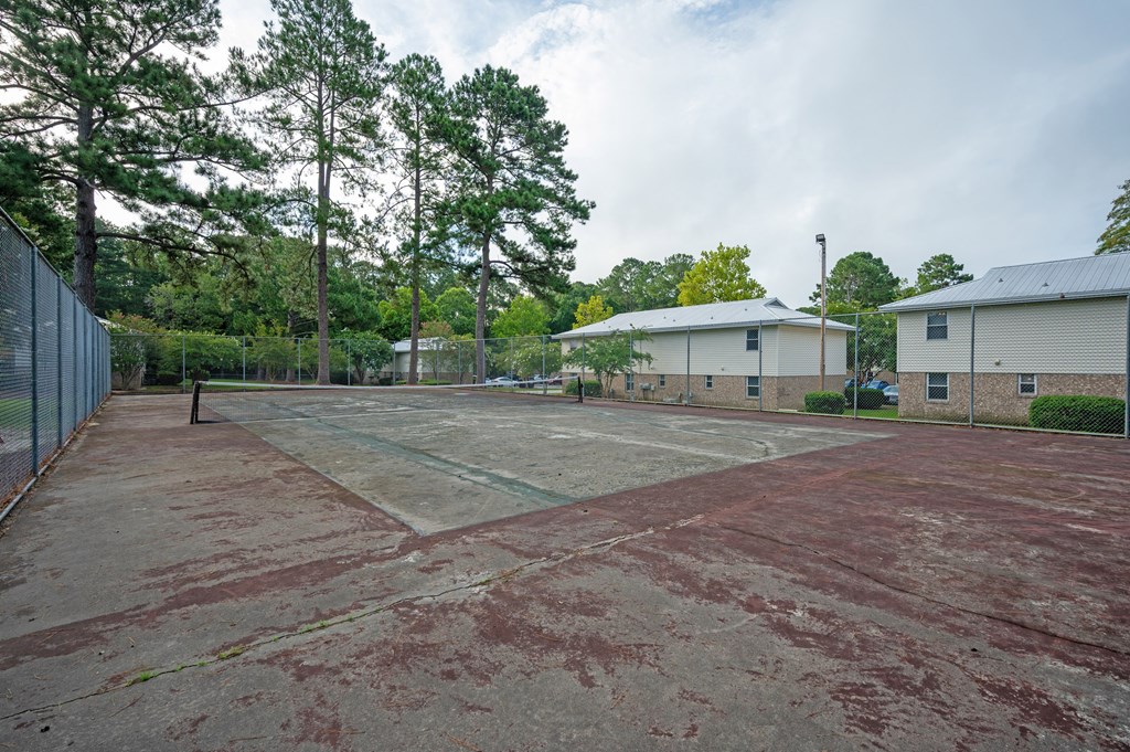 A basketball court with a chain link fence and basketball hoops at Woodlocke Apartments, Moncks Corner, SC, 27461