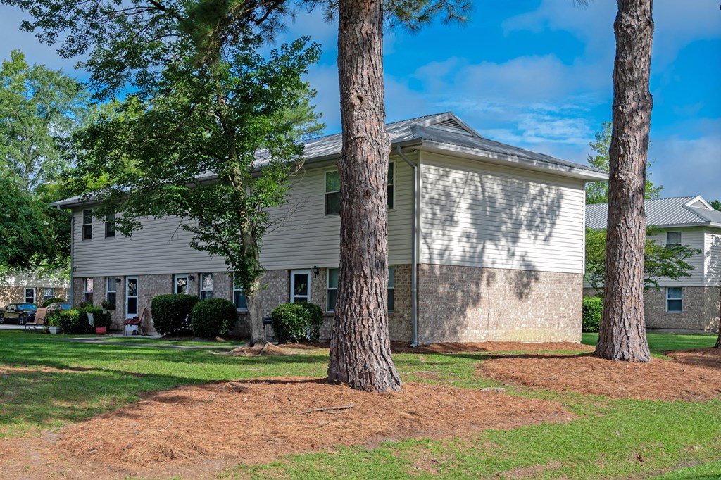 A house with a grey roof and a tree in front of it at Woodlocke Apartments, Moncks Corner 27461