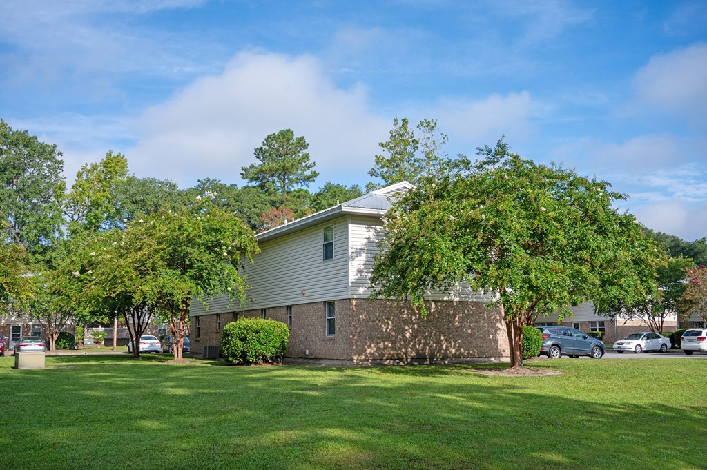 A house with a white roof and a green lawn in front at Woodlocke Apartments, Moncks Corner, South Carolina