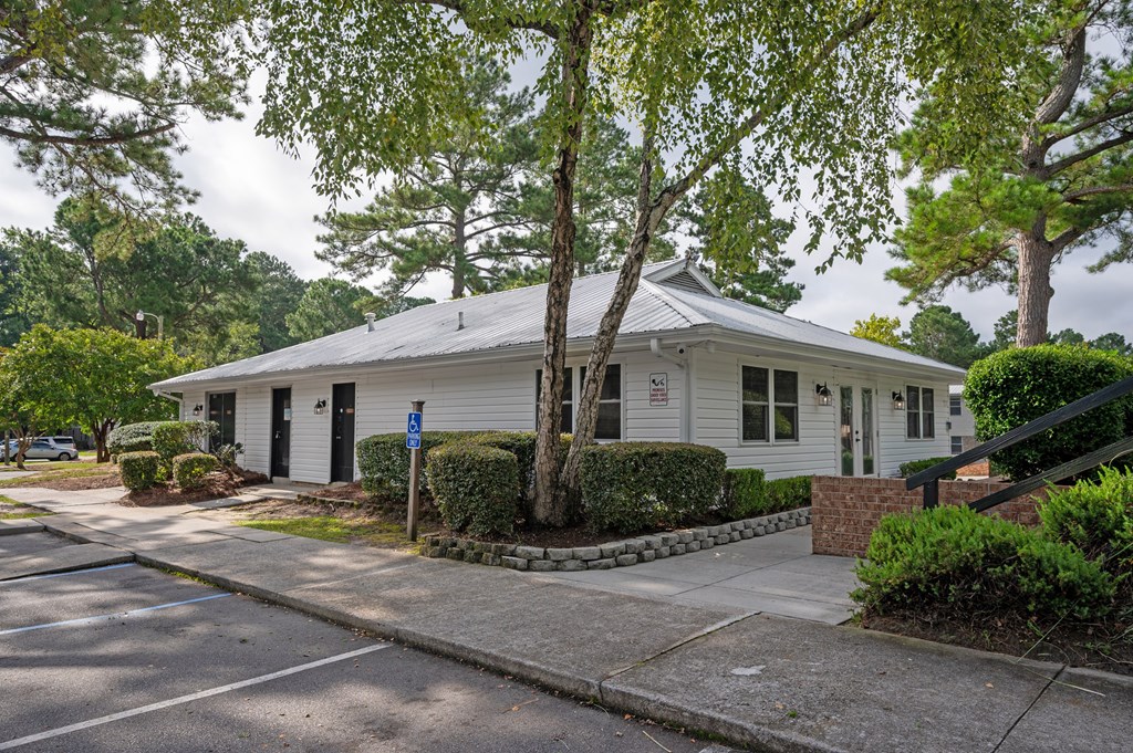 A white house with a blue sign in front of it at Woodlocke Apartments, South Carolina