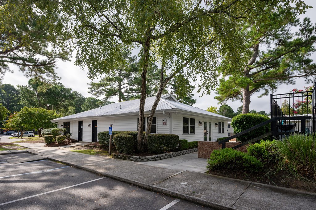 A white building with a black gate in front at Woodlocke Apartments, South Carolina, 27461