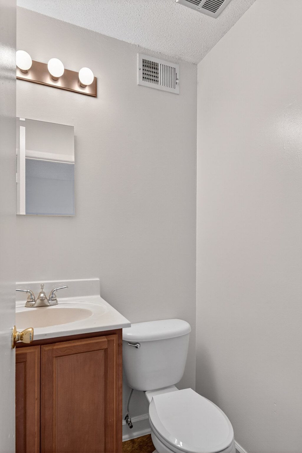 A white toilet sits next to a sink in a bathroom at Woodlocke Apartments, Moncks Corner, South Carolina