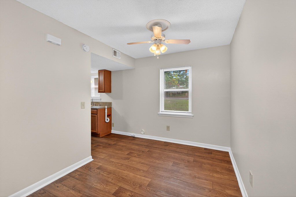 A room with a ceiling fan and wooden flooring at Woodlocke Apartments, Moncks Corner