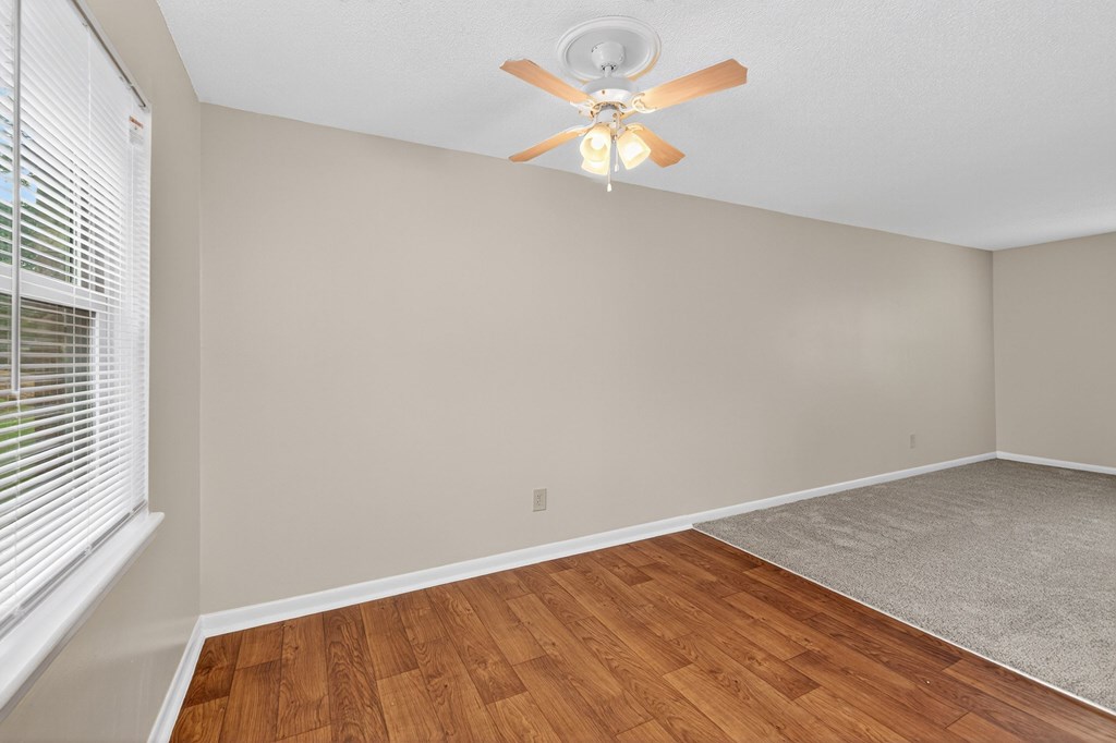 A room with a ceiling fan and wooden flooring at Woodlocke Apartments, Moncks Corner, SC, 27461