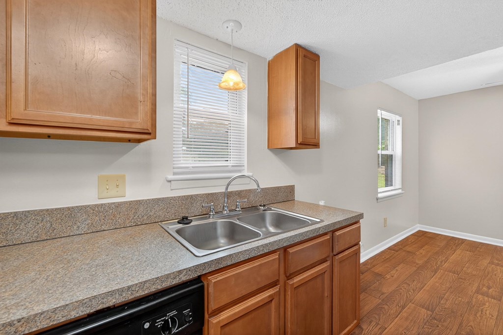 A kitchen with wooden cabinets and a granite countertop at Woodlocke Apartments, Moncks Corner, South Carolina
