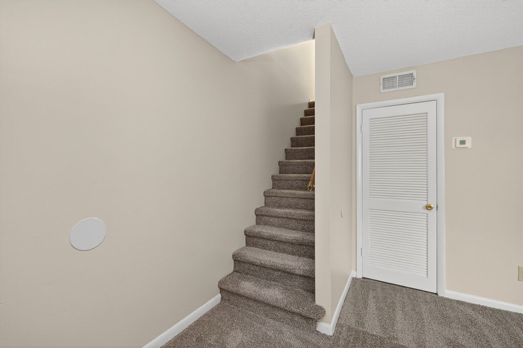 A staircase with a white door at the top at Woodlocke Apartments, Moncks Corner