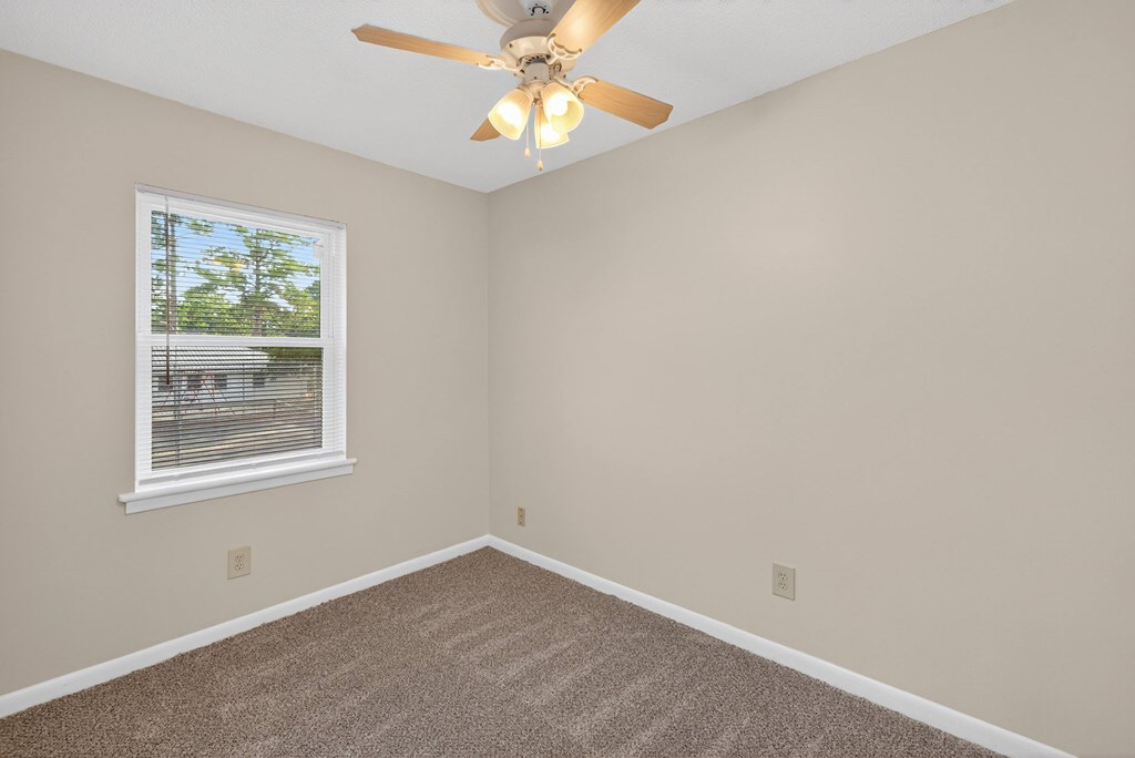 A room with a ceiling fan and a window at Woodlocke Apartments, Moncks Corner, South Carolina