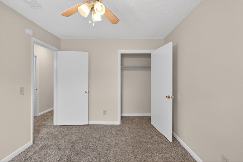 A room with a ceiling fan and two doors at Woodlocke Apartments, South Carolina