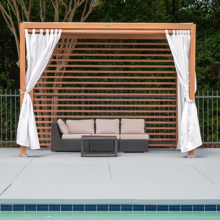 A poolside lounge area with a white canopy and a brown lattice backdrop at The Preserve at Pine Valley Apartments, Wilmington, NC 28412