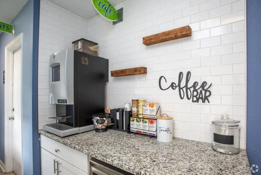 A coffee bar with a black fridge and a white counter at The Preserve at Pine Valley Apartments, Wilmington