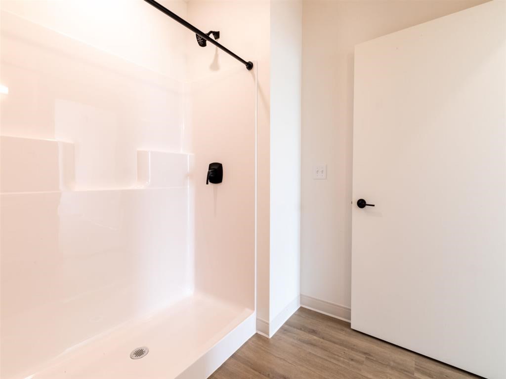 A white bathroom with a white tub and a white door.