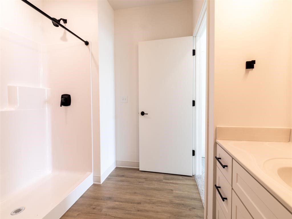 A white door is in a bathroom with a white tub and a white sink.