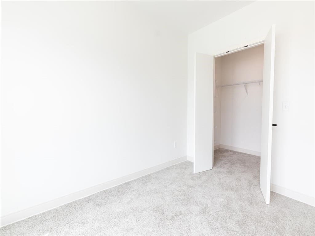 A white door is open to a room with a carpeted floor.