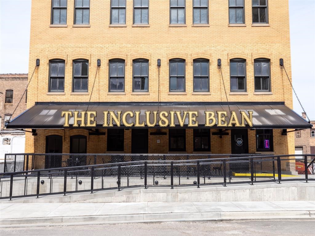 The Inclusive Bean building has a black awning.