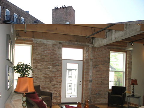 A living room with a white door and a brick wall.
