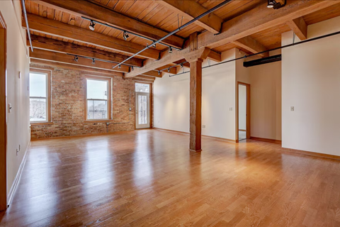 A large empty room with wooden floors and exposed beams.