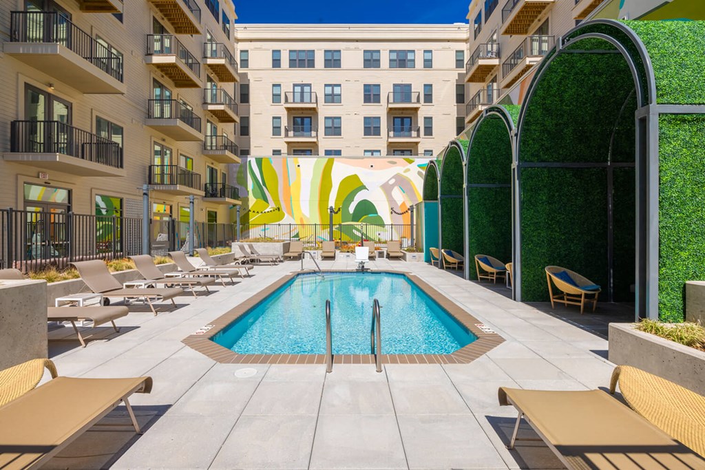A pool surrounded by lounge chairs and umbrellas.at The Vale at the Parks, Washington, DC 20012  