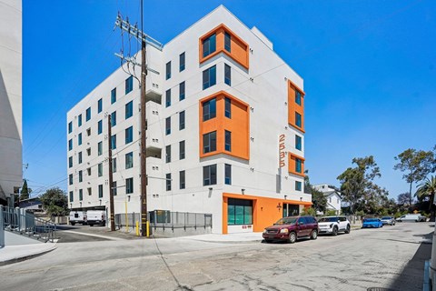 A white building with orange accents stands on a street corner.