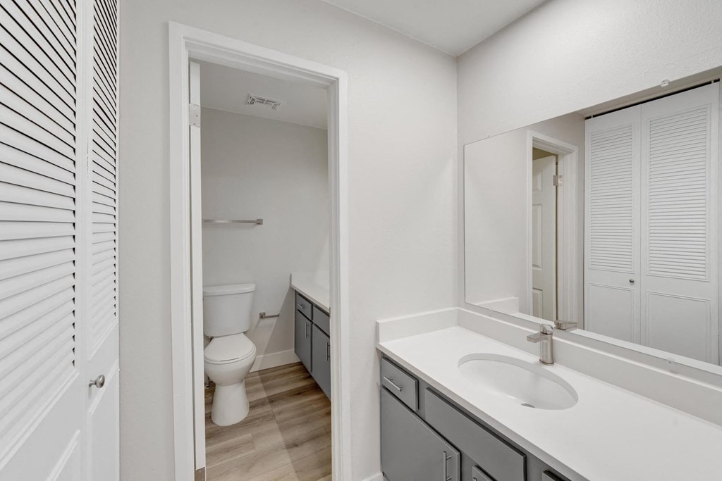 A white bathroom with a toilet and sink. at The Lex At Lowry, Denver, Colorado