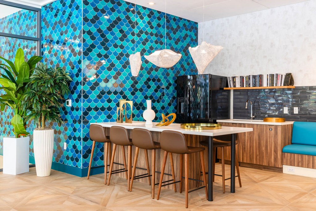 A kitchen with a blue tiled wall and wooden chairs.at The Vale at the Parks, District of Columbia, 20012