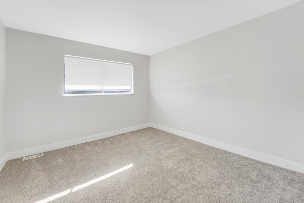 A room with a carpeted floor and a window. at The Lex At Lowry, Denver, Colorado
