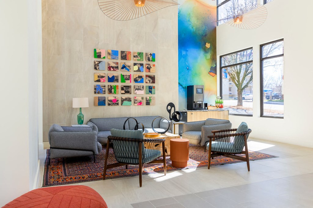 A living room with a grey couch, a green chair, a brown table and a wall with pictures.at The Vale at the Parks, Washington, 20012  