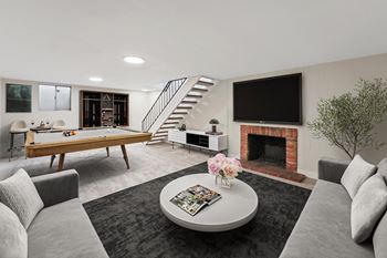 A living room with a grey couch, a coffee table, a fireplace, and a television. at The Lex At Lowry, Denver