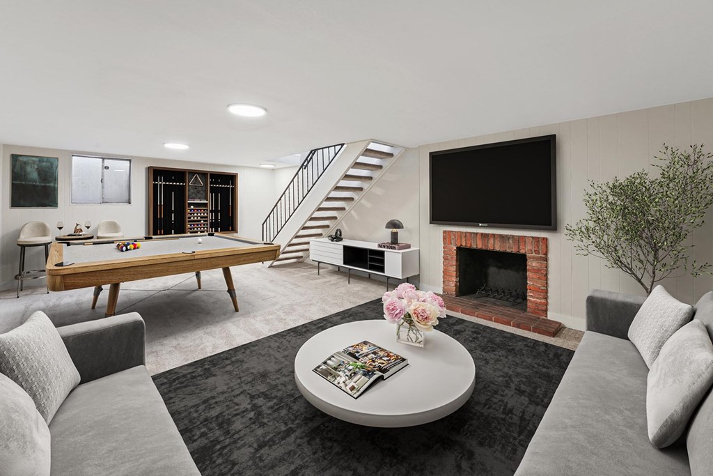 A living room with a grey couch, a coffee table, a fireplace, and a television. at The Lex At Lowry, Denver, CO