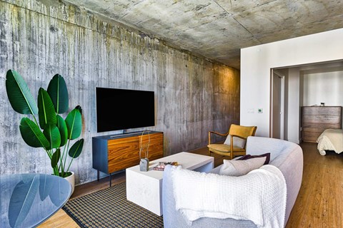 A living room with a white couch and a wooden cabinet.