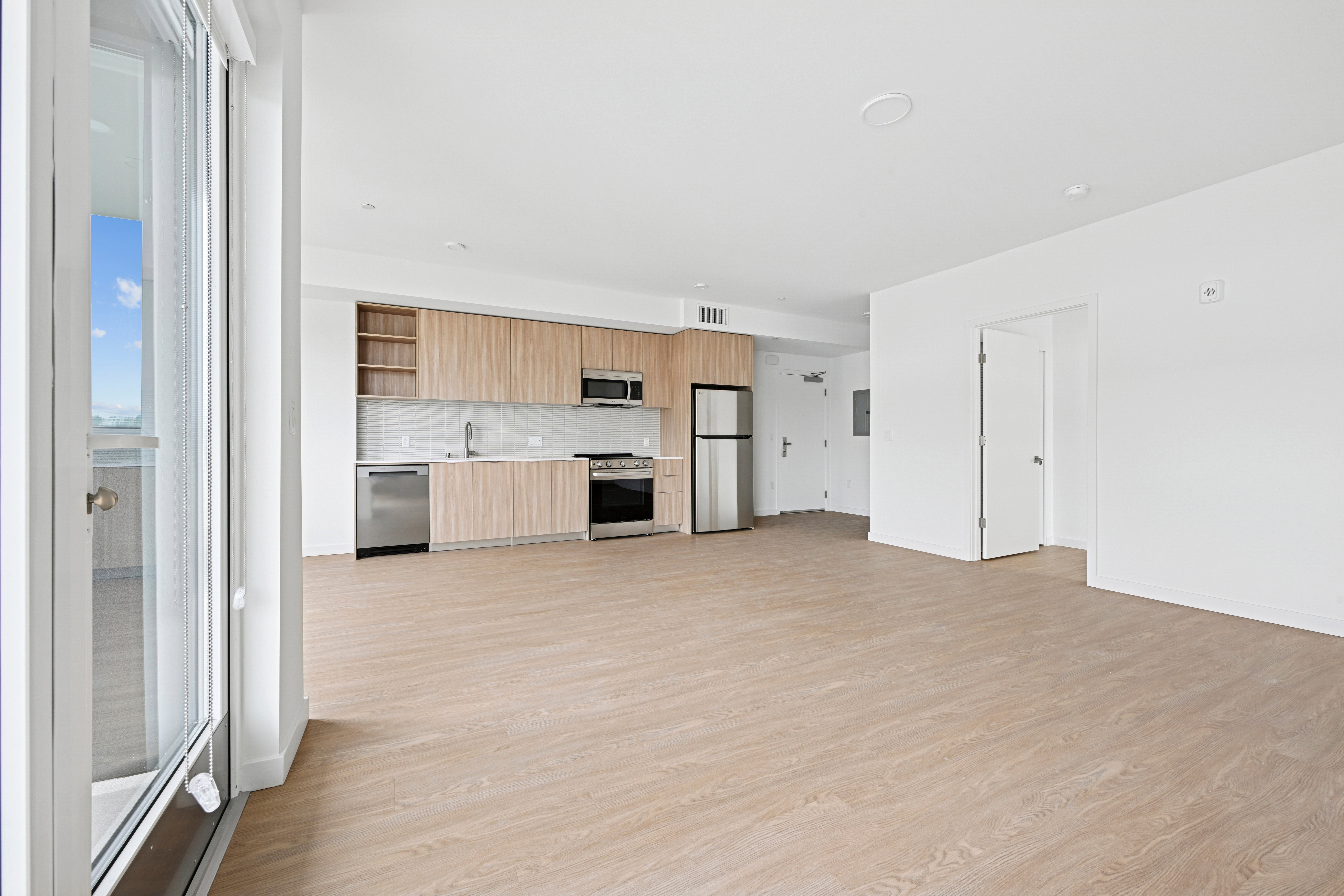 A modern kitchen with wooden floors and white walls.