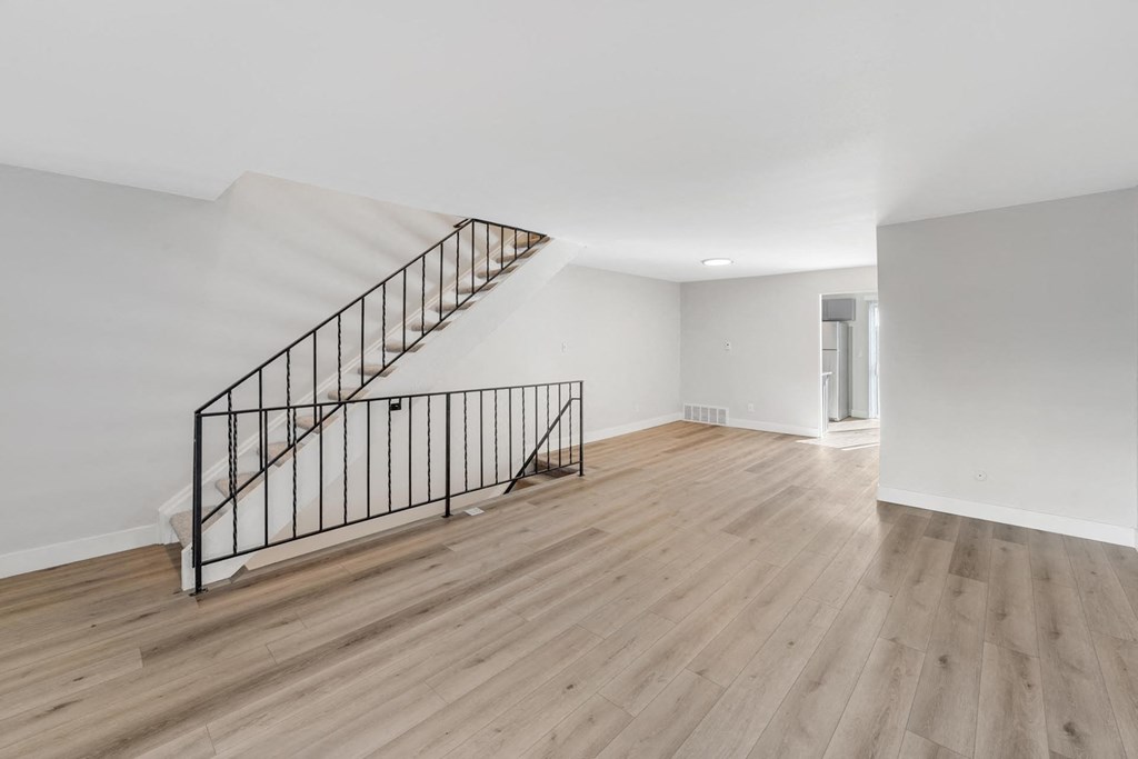 A wooden staircase with a metal railing leads to a second floor. at The Lex At Lowry, Denver, Colorado