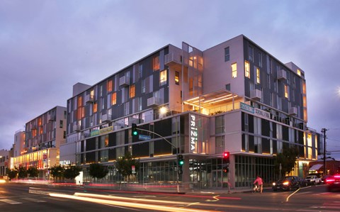 A modern building with a glass facade and a lit up sign that reads "PRINZA".